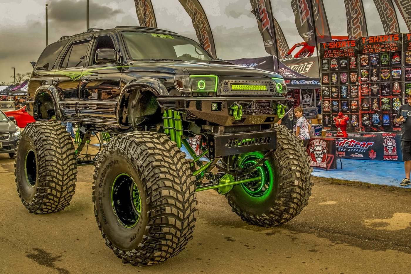 A heavily customized, lifted SUV on display at a truck show, shot by a real working photographer